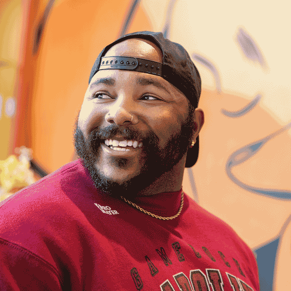 Garrison Gists stands in front of his mural at Uptown Yolk in Charlotte, North Carolina